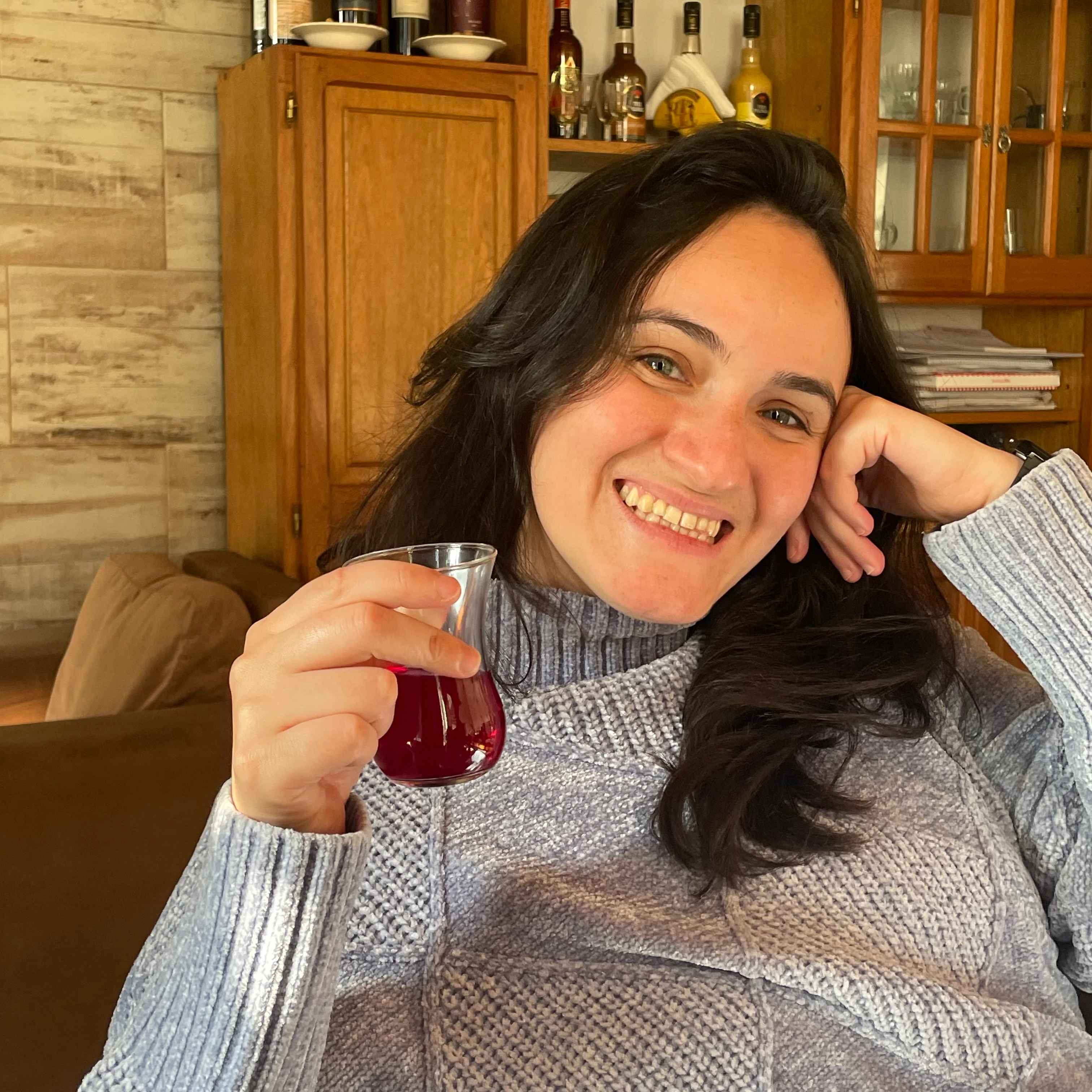 Photograph of Cami drinking Turkish tea at my father's house, 2026.